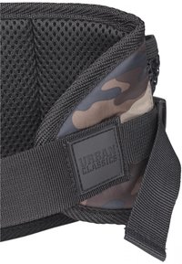 Cinturino in rete nera con una finitura testurizzata e un accentuato motivo camouflage. Presenta un patch in gomma con il logo "Urban Classics".