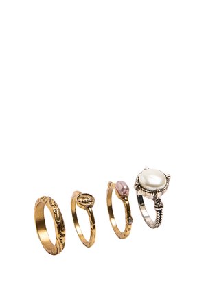 Cztery ozdobne pierścienie w rzędzie, z trzema złotymi teksturowanymi obrączkami i jedną srebrną obrączką z dużą, okrągłą perłą.