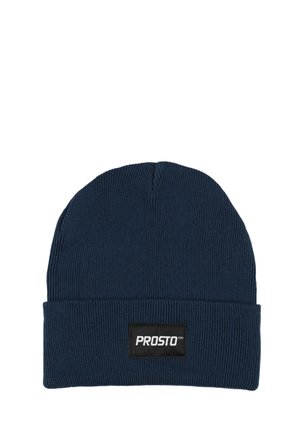 Granatowa prążkowana dziana czapka z wywiniętym mankietem i prostokątną czarną metką z białym napisem. Miękki, elastyczny materiał.