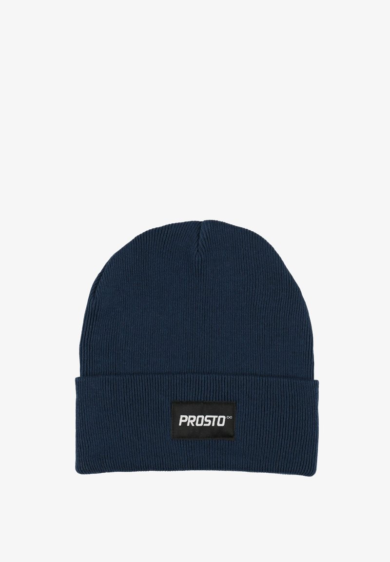 Granatowa prążkowana dziana czapka z wywiniętym mankietem i prostokątną czarną metką z białym napisem. Miękki, elastyczny materiał.
