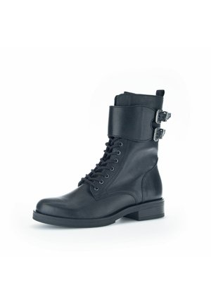 Schwarze Leder-Stiefelette mit Schnürung, gepolstertem Knöchelriemen und zwei silbernen Schnallendetails. Flache Sohle und abgerundete Zehenform.