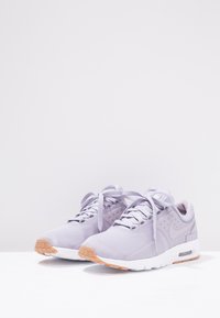 Nike-sneakers i ljus lavendelmesh, med en texturerad yta, rund tå, vit mellansula och ljusbrun gummiyttersula.