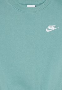 Majica mint zelene barve iz mehkega bombaža, s krožnim izrezom in belim Nike logotipom izšitim na prsih.