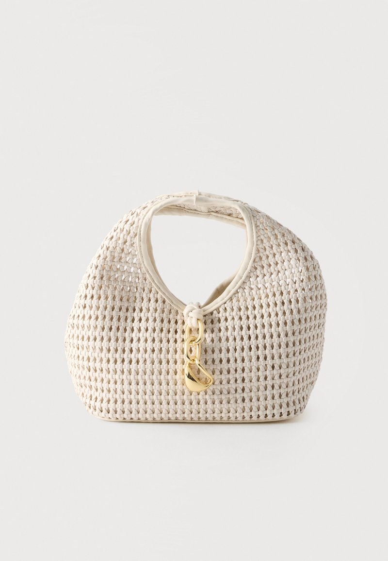Kremfarget vevd håndveske med avrundet form, kort håndtak og dekorativ gullfarget spenne som henger på fronten midt på.