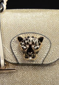 Bolso de mano de purpurina dorada con un cierre en forma de pantera negro y dorado con acentos de rhinestones. Textura suave con un diseño estructurado.