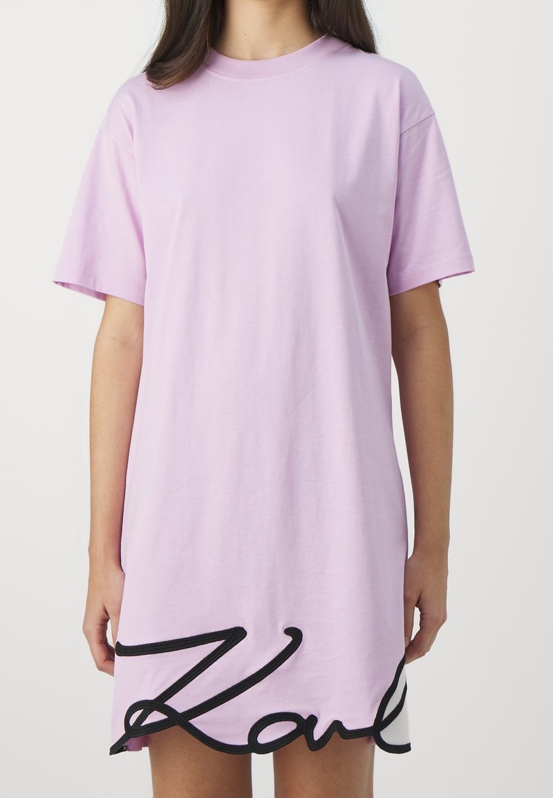 Sukienka bawełniana w kolorze liliowym z krótkim rękawem, z czarnym haftem "Karl" na dole, o luźnym kroju i okrągłym dekolcie.