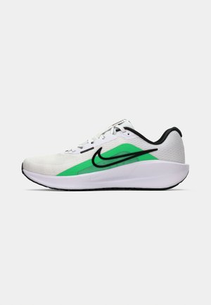 White athletic shoe with a green accent, black logo, mesh upper, cushioned sole, and a rounded heel. Features laces and contrast detailing.