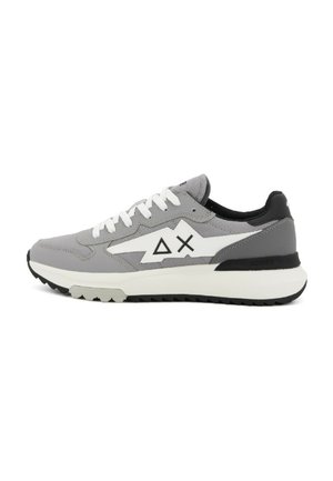 Chaussure de sport grise avec un mélange de matériaux lisses et texturés, accents blancs, logo géométrique et talon noir. Semelle en caoutchouc.
