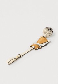 Nahast aksessuaar beežide toonidega, kreemja rihmaga, keerukate läbiväljalõigete ja tekstureeritud pompon-detailiga.