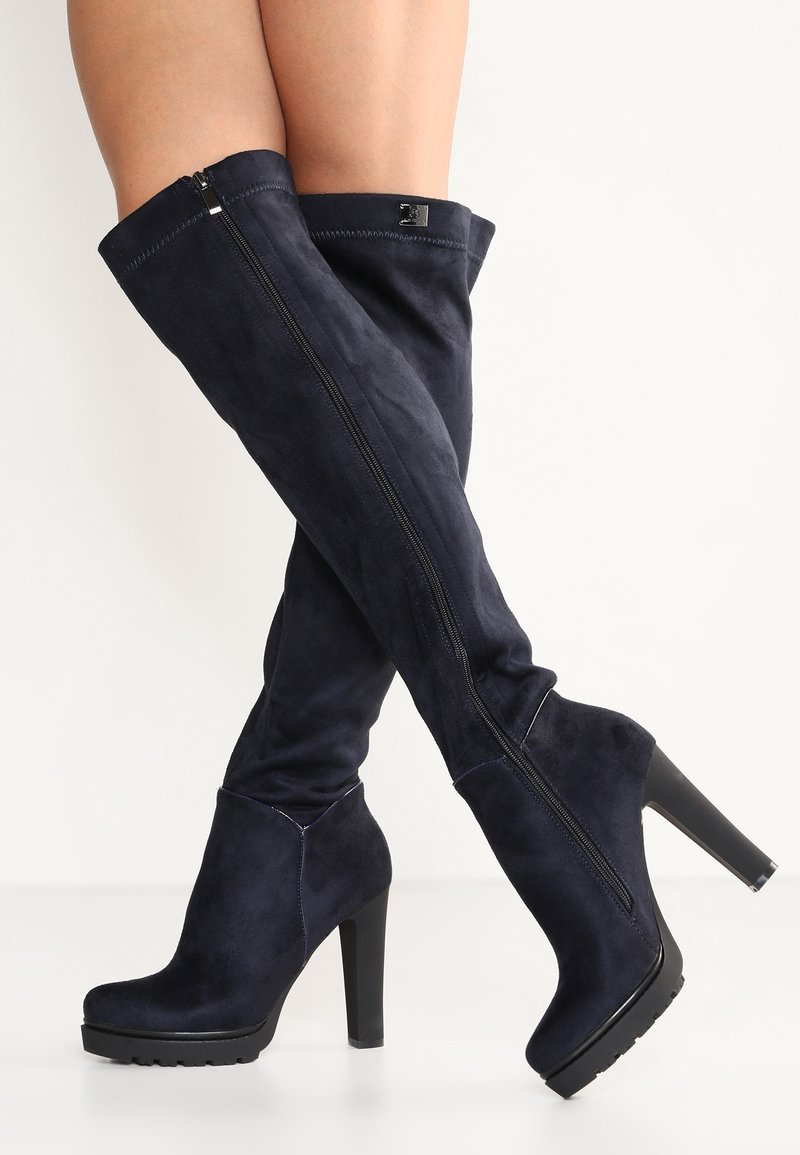 Botas de ante azul marino hasta la rodilla con tacón alto negro y plataforma, con cremallera lateral y costuras sin costura.