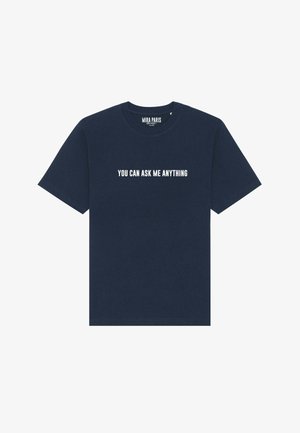 Navyblauwe katoenen t-shirt met korte mouwen en een ronde hals. Voorzien van witte tekst die op de voorkant "JE KUNT ME ALLES VRAGEN" zegt.