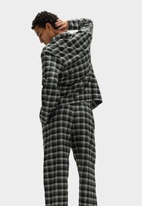 Conjunto de loungewear de cuadro negro y gris con un ajuste relajado. Tejido suave, mangas largas y cintura elástica para mayor comodidad.