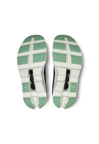 Athletic shoes with a textured green and white rubber sole. Features a multi-sectioned design with diagonal grooves and a central black locking mechanism.