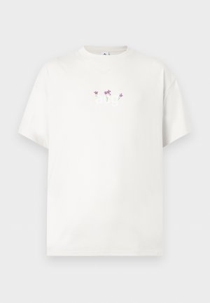 Weißes T-Shirt mit kurzen Ärmeln mit kleinen lila Blumen und hellgrünen Stängeln, die unterhalb des Kragens auf der Brust bestickt sind.