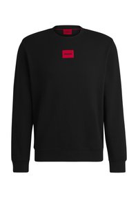 Svart sweatshirt i mjukt tyg, med rund halsringning och långa ärmar. En röd rektangulär logotypapplikation är centrerad på bröstet.