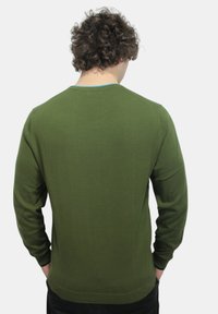Maglione verde lavorato a maglia con scollo a girocollo, maniche lunghe e design aderente. Texture liscia con polsini e orlo a coste.