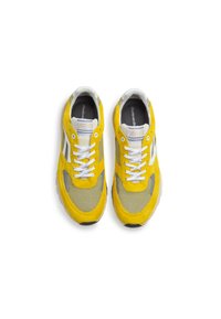 Sneakers gialli con lacci bianchi, caratterizzati da un design in rete e accenti grigi, mostrati da una prospettiva dall'alto su uno sfondo bianco.