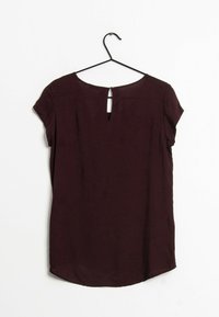 Top corto bordeaux a maniche corte con scollatura rotonda e un piccolo dettaglio a chiave sul retro, realizzato in un tessuto leggero con una texture liscia.