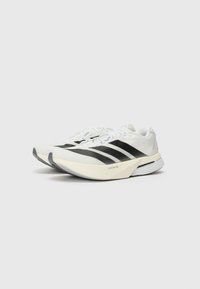 White athletic shoes with black stripes, lightweight mesh upper, rounded toe, textured sole, and contrasting accents on the sole design.