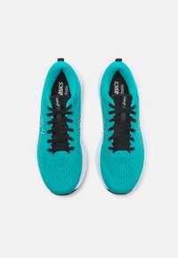 Chaussures de sport turquoise avec une tige en mesh, lacets noirs et semelle blanche. Présente de petites perforations pour la respirabilité et une marque sur la languette.