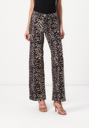 Leopardenprint wijde broek met een gladde textuur, hoge taille en knopendetails. Gecombineerd met beige strappy hakken.