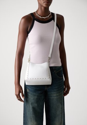 Sac crossbody clouté blanc en cuir synthétique texturé ; présente un dessus arrondi, une sangle réglable et des accents en métal doré.