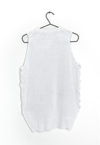 Top de punto blanco sin mangas con lados abiertos, que presenta detalles de cordones. Tejido texturizado y un diseño relajado y suelto.