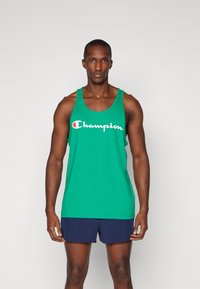 Grøn bomulds tanktop med rund halsudskæring og brede skulderstropper, prydet med et hvidt "Champion" logo over brystet.