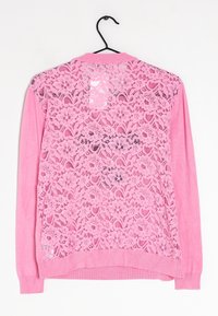 Cárdigan rosa con un frontal liso y una espalda de encaje floral, con puños y dobladillo acanalados para un contraste de textura.