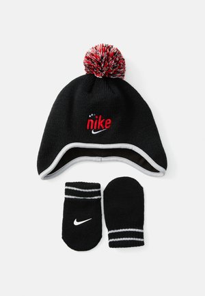 Gorro de inverno preto da Nike com pompom vermelho e branco e logo, combinado com luvas pretas com riscas brancas e um swoosh branco da Nike.