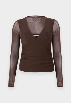 Haut marron à manches longues avec manches en maille transparente et décolleté en V, présentant une taille cintrée et un léger froncé sur les côtés.