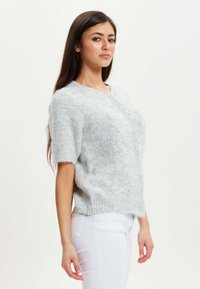 Light gray short-sleeve cardigan made from soft, textured fabric, featuring a round neckline and five buttons down the front.