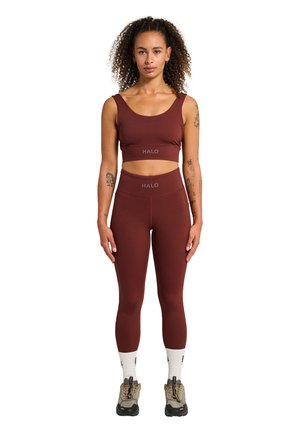 Bordeaux atletisk crop top og højtaljede leggings sæt, der har glat stof og HALO-logo detaljer. Modellen har hvide sokker og brune sko på.