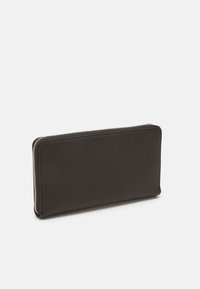 Black leather wallet with a smooth texture, rectangular shape, and a zip closure. Features white stitching along the edges.