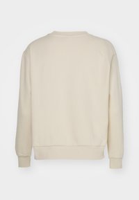 Sudadera de manga larga color crema con puños, dobladillo y cuello redondo acanalados, vista desde atrás sobre un fondo blanco liso.
