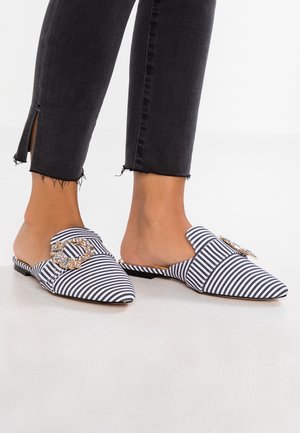 Stribet stofmule i navy og hvid, med spids tå og udsmykket med en dekorativ guld- og krystaldetalje.