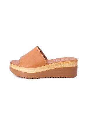 Sandalo scivoloso in pelle color tan con una fascia larga, suola piatta in legno e fondo testurizzato per una buona presa. Finitura liscia e design con punta arrotondata.