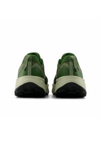 Une paire de chaussures de trail vertes vue de l'arrière, avec des languettes de traction, des semelles intermédiaires rembourrées et des semelles extérieures noires robustes.