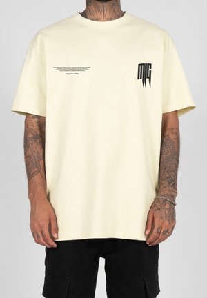 Helles gelbes T-Shirt mit Rundhalsausschnitt und kurzen Ärmeln. Mit schwarzem Text und Logo auf der Vorderseite. Weiches Baumwollmaterial, lässige Passform.