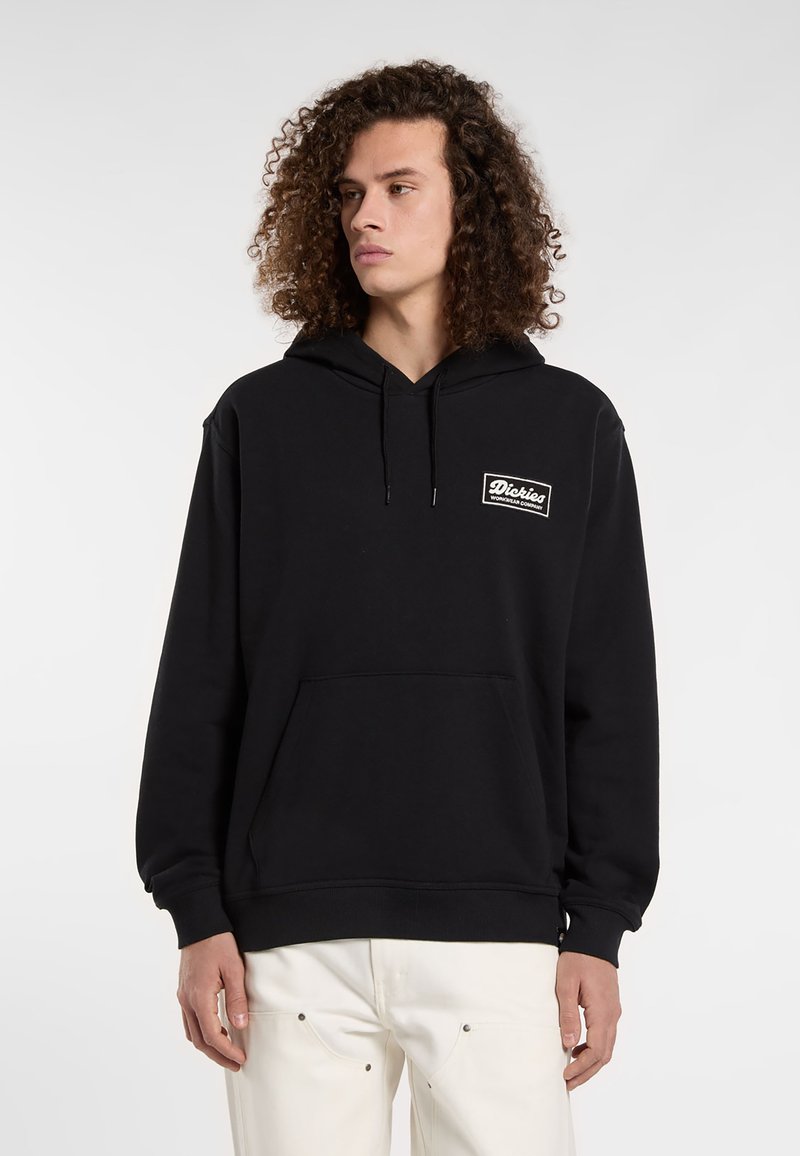 Felpa nera in cotone, con tasca frontale, cappuccio con cordini e un piccolo logo bianco sul lato sinistro del petto.