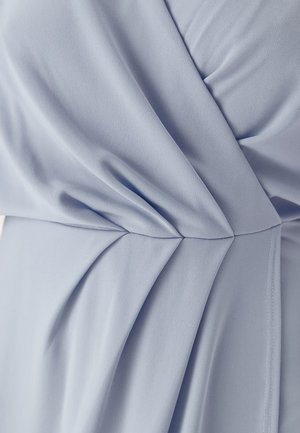 Lichtblauwe jurk van glad, zacht stof met diagonale plooien die voor textuur zorgen. Naaddetails aan de zijkanten verbeteren het ontwerp.