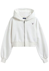 Geknipte witte hoodie van zacht materiaal, met een rits aan de voorkant, lange pofmouwen, geribde boord en een klein logo op de borst.