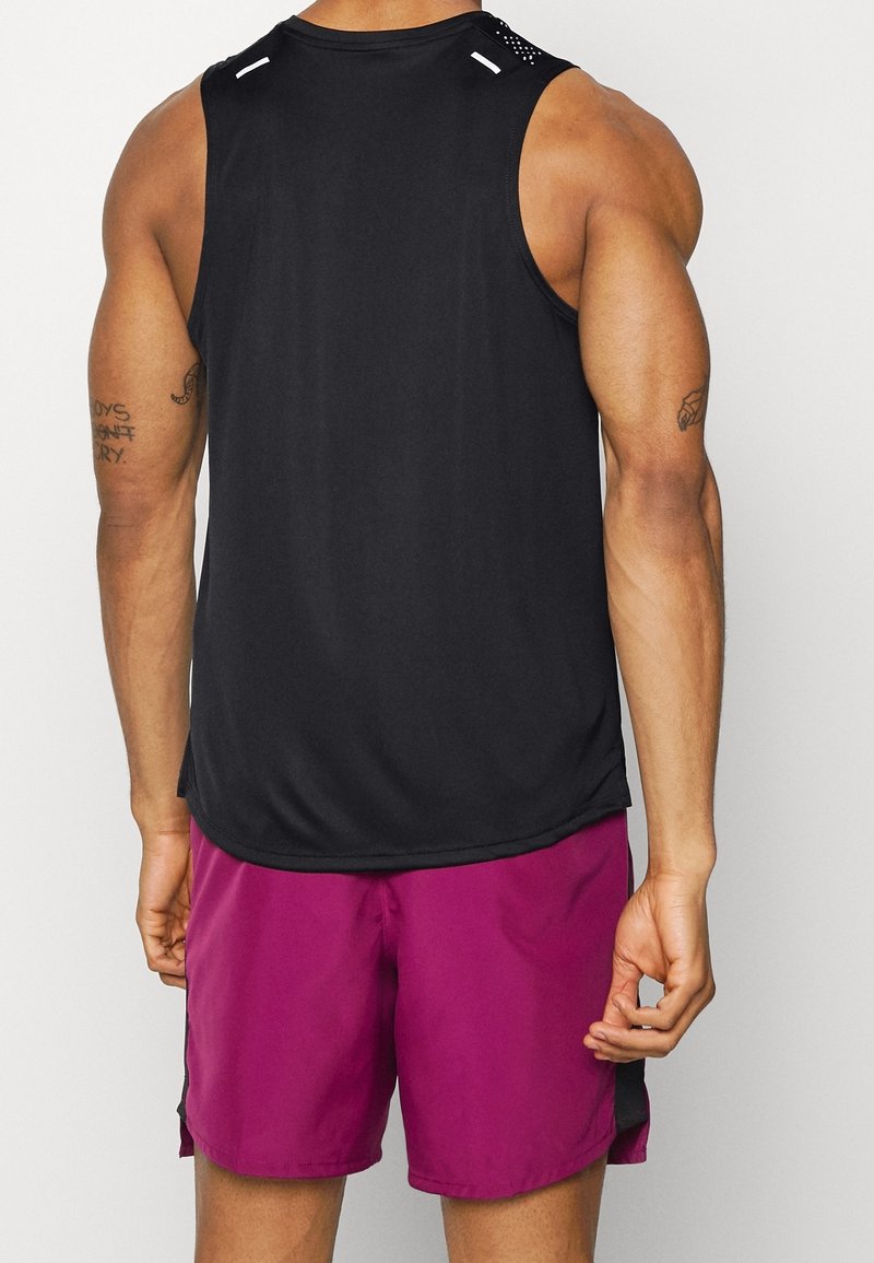 T-shirt de sport sans manches noire avec des accents en maille aux épaules, associé à un short violet vif, doté d'une texture lisse et légère.