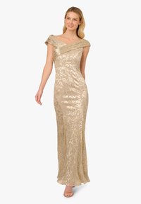 Goldenes Abendkleid mit schulterfreiem Design, strukturiertem Blumenmuster und figurbetonter Silhouette, das bis zum Boden reicht.