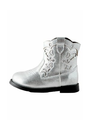 Sølv cowboystøvle lavet af metalisk syntetisk materiale, med et dekorativt udskæringsdesign og en sort gummisål. Rund tåform.