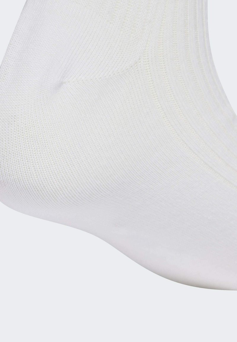 Calzino bianco alla caviglia realizzato in un materiale lavorato a maglia liscio, con un design a coste sulla parte superiore. L'area delle dita è leggermente arrotondata.