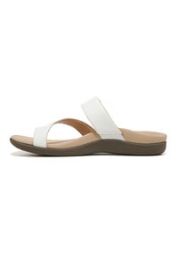 White synthetic slide sandals with a wide cross-strap and low, cushioned brown sole. Simple design, flat footbed.