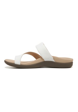 White synthetic slide sandals with a wide cross-strap and low, cushioned brown sole. Simple design, flat footbed.