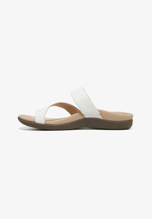 White synthetic slide sandals with a wide cross-strap and low, cushioned brown sole. Simple design, flat footbed.