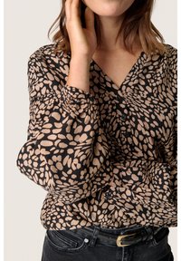 Blusa nera con motivo astratto beige, scollo a V e maniche lunghe a sbuffo. Include dettagli con bottoni e tessuto arricciato sulle spalle.